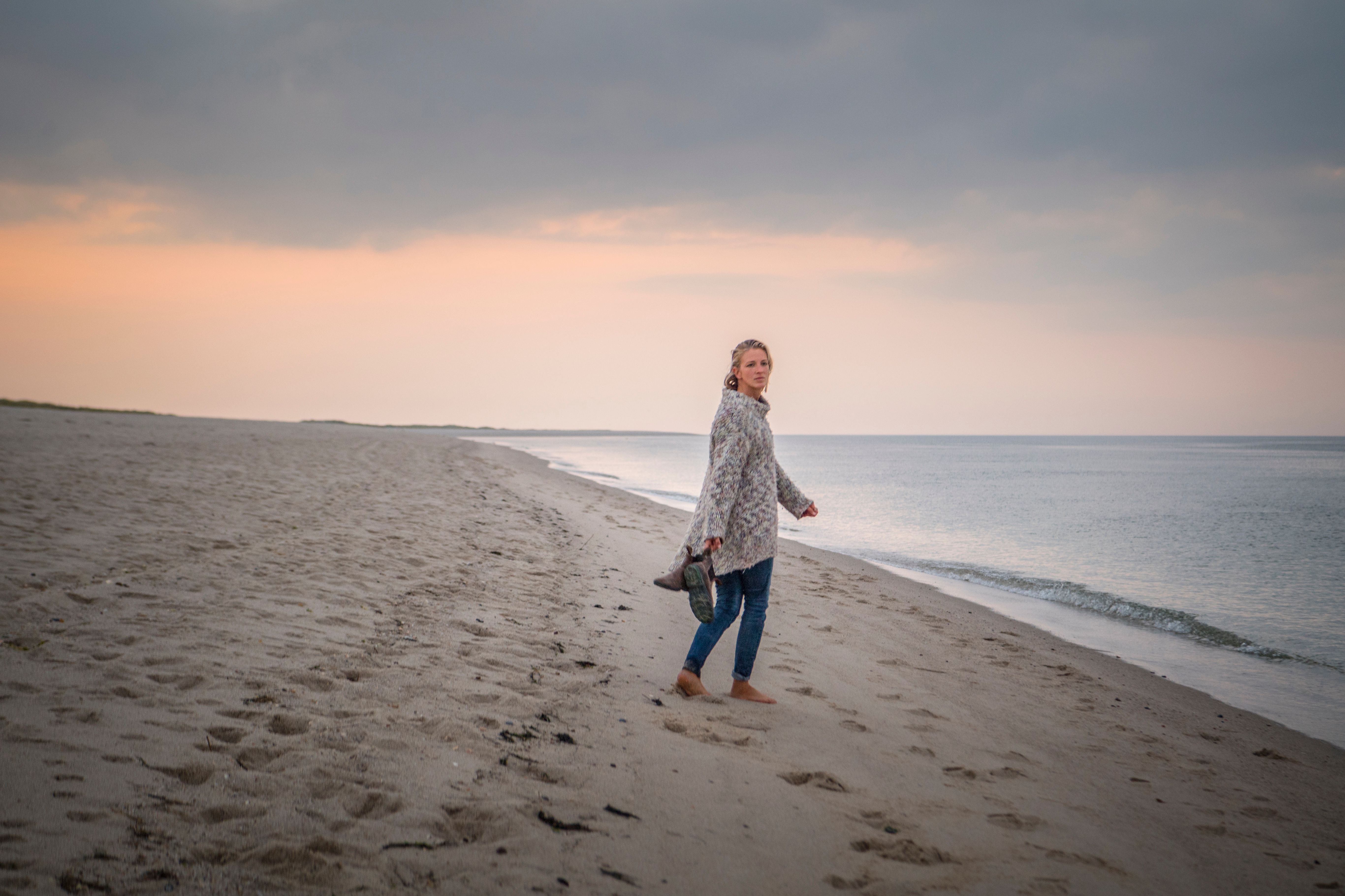 Eine Frau geht in ihrem Nordsee-Urlaub am Sylter Ellenbogen wandern.